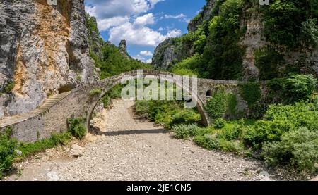 Die Brücke von Kokoros oder Noutsos wölbt sich anmutig über das je nach Saison trockene Flussbett in der oberen Vikos-Schlucht in Zagori Griechenland Stockfoto