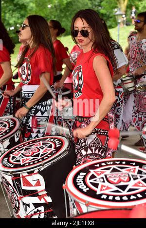 Frau in Batala Trommingband, die im Outdoor-Bandstand, Bristol, Großbritannien, auftrat Stockfoto