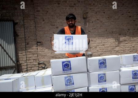 23. Juni 2022, Peshawar, khyber pakhtunkhwa, Pakistan: Mitarbeiter der Alkhidmat-Stiftung verladen Hilfsgüter auf Lieferwagen, um nach Chamkani nach afghanischen Erdbebenopfern zu versenden. Mehr als 1.000 Menschen wurden getötet und mehr als 1.500 weitere verletzt, nachdem ein Erdbeben der Stärke 5,9 vor Sonnenaufgang am 22. Juni Ostafghanistan getroffen hatte, berichtete die staatliche afghanische Nachrichtenagentur Bakhtar. Nach Angaben der Behörden dürfte die Zahl der Todesopfer steigen. (Bild: © Hussain Ali/Pacific Press via ZUMA Press Wire) Stockfoto