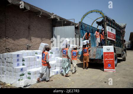 23. Juni 2022, Peshawar, khyber pakhtunkhwa, Pakistan: Mitarbeiter der Alkhidmat-Stiftung verladen Hilfsgüter auf Lieferwagen, um nach Chamkani nach afghanischen Erdbebenopfern zu versenden. Mehr als 1.000 Menschen wurden getötet und mehr als 1.500 weitere verletzt, nachdem ein Erdbeben der Stärke 5,9 vor Sonnenaufgang am 22. Juni Ostafghanistan getroffen hatte, berichtete die staatliche afghanische Nachrichtenagentur Bakhtar. Nach Angaben der Behörden dürfte die Zahl der Todesopfer steigen. (Bild: © Hussain Ali/Pacific Press via ZUMA Press Wire) Stockfoto