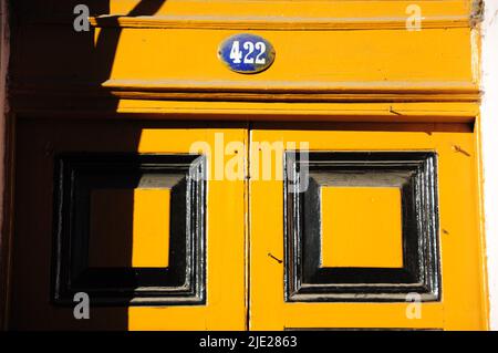 Details der Eingangstür eines Hauses in der Nachbarschaft von La Boca in Buenos Aires Argentinien.die Tür ist gelb mit schwarzen Details lackiert und Sie können Stockfoto