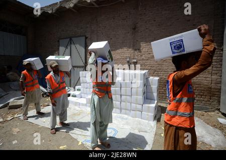 23. Juni 2022, Peshawar, khyber pakhtunkhwa, Pakistan: Mitarbeiter der Alkhidmat-Stiftung verladen Hilfsgüter auf Lieferwagen, um nach Chamkani nach afghanischen Erdbebenopfern zu versenden. Mehr als 1.000 Menschen wurden getötet und mehr als 1.500 weitere verletzt, nachdem ein Erdbeben der Stärke 5,9 vor Sonnenaufgang am 22. Juni Ostafghanistan getroffen hatte, berichtete die staatliche afghanische Nachrichtenagentur Bakhtar. Nach Angaben der Behörden dürfte die Zahl der Todesopfer steigen. (Bild: © Hussain Ali/Pacific Press via ZUMA Press Wire) Stockfoto