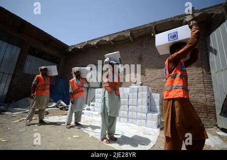 23. Juni 2022, Peshawar, khyber pakhtunkhwa, Pakistan: Mitarbeiter der Alkhidmat-Stiftung verladen Hilfsgüter auf Lieferwagen, um nach Chamkani nach afghanischen Erdbebenopfern zu versenden. Mehr als 1.000 Menschen wurden getötet und mehr als 1.500 weitere verletzt, nachdem ein Erdbeben der Stärke 5,9 vor Sonnenaufgang am 22. Juni Ostafghanistan getroffen hatte, berichtete die staatliche afghanische Nachrichtenagentur Bakhtar. Nach Angaben der Behörden dürfte die Zahl der Todesopfer steigen. (Bild: © Hussain Ali/Pacific Press via ZUMA Press Wire) Stockfoto