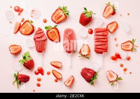 Eiszapfen und frische Erdbeeren auf rosa Hintergrund. Stockfoto