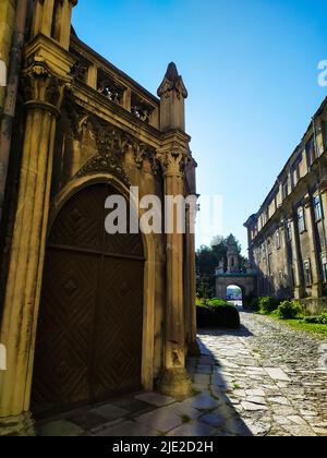 Zweiblättrige Holztür unter einem halbrunden Steinbogen Stockfoto
