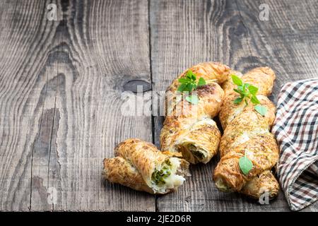 Blätterteiggeflecht, gefüllt mit Hackfleisch auf einem Holztisch Stockfoto