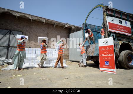 Peshawar, Pakistan. 23.. Juni 2022. Mitarbeiter der Alkhidmat-Stiftung verladen Hilfsgüter auf Lieferwagen, um nach afghanischen Erdbebenopfern in Chamkani zu versenden. Mehr als 1.000 Menschen wurden getötet und mehr als 1.500 weitere verletzt, nachdem ein Erdbeben der Stärke 5,9 vor Sonnenaufgang am 22. Juni Ostafghanistan getroffen hatte, berichtete die staatliche afghanische Nachrichtenagentur Bakhtar. Nach Angaben der Behörden dürfte die Zahl der Todesopfer steigen. (Foto: Hussain Ali/Pacific Press/Sipa USA) Quelle: SIPA USA/Alamy Live News Stockfoto