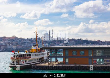 Blick auf Istanbul. Karakoy Pier und eine Fähre mit der Suleymaniye Moschee im Hintergrund. Istanbul Türkei - 3.2.2022 Stockfoto