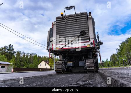 Rückansicht einer Kaltfräsmaschine und Schnitt Asphalt auf der Straße Stockfoto