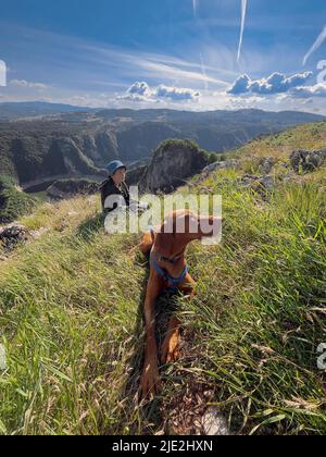 Kind mit Hund in Ruhe am River Canyon Stockfoto