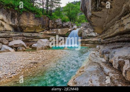 Landschaftlich schöner kleiner Wasserfall mit klarem Wasser in der Bergschlucht. Schöner Wasserfall in Gorges de la Meouge, Provence, Frankreich. Stockfoto