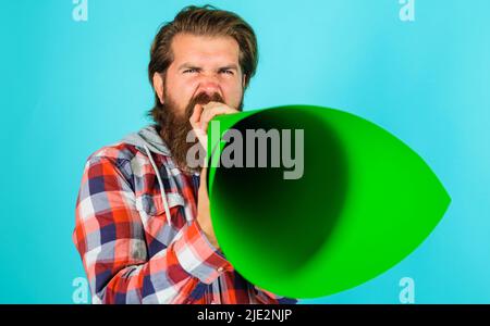 Bärtiger Mann, der in Lautsprecher oder Megaphon schreit. Redefreiheit. Ankündigung oder Verbreitung von Nachrichten. Stockfoto