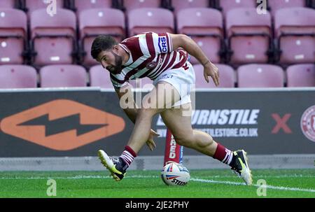 Wigan WarriorsÕ Abbas Miski punktet seine Spielpartner beim siebten Versuch während des Betfred Super League-Spiels im DW Stadium, Wigan. Bilddatum: Freitag, 24. Juni 2022. Stockfoto