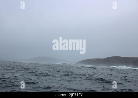 Welle krachend gegen kleine Eisberge, die im Meer schweben Stockfoto