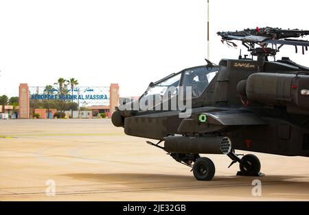 Am 20. Juni 2022 wird ein Hubschrauber der AH-64D Apache vom Angriffs-Aufklärungsbataillon 1., 1-211. Aviation Regiment, Utah Army National Guard, auf dem Internationalen Flughafen Agadir Al-Massira, Marokko, mit dem Flugzeug besteuert. AL22 ist die größte, führende, gemeinsame, kombinierte jährliche Übung des US Africa Command, die vom 6. Bis 30. Juni von Marokko, Ghana, Senegal und Tunesien veranstaltet wird. Mehr als 7.500 Teilnehmer aus 28 Nationen und der NATO trainieren zusammen mit dem Fokus auf die Verbesserung der Bereitschaft für US- und Partnernationskräfte. AL22 ist eine gemeinsame Alldomäne-, Mehrkomponenten- und multinationale Übung, bei der ein vollständiges Spektrum an Mi-Mitarbeitern eingesetzt wird Stockfoto