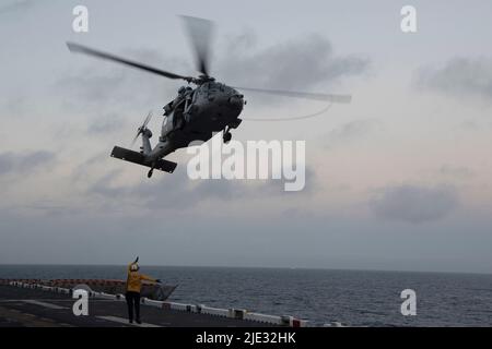 220623-N-XN177-2143 PAZIFISCHER OZEAN (23. Juni 2022) – ein Hubschrauber vom Typ MH-60s Sea Hawk, der dem Hubschrauber Sea Combat Squadron (HSC) 23 zugewiesen wurde, hebt am 23. Juni 2022 vom Flugdeck des amphibischen Angriffsträgers USS Tripoli (LHA 7) ab. Tripolis ist im Einsatzgebiet der US-Flotte von 7. tätig, um die Interoperabilität mit Verbündeten und Partnern zu verbessern und als einsatzbereite Einsatztruppe für den Frieden und die Stabilität in der Region Indo-Pazifik zu dienen. (USA Navy Foto von Mass Communication Specialist 1. Klasse Peter Burghart Stockfoto