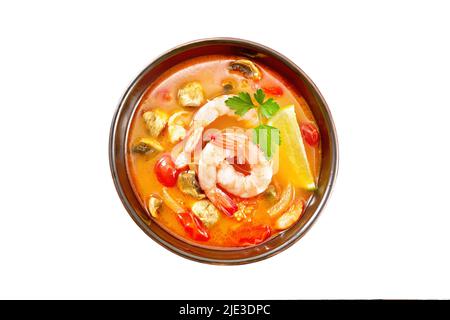 Thai-Suppe Tom Yam aus Garnelen, Hühnerfleisch mit Pilzen, Tomaten und Zitrone in einer Schüssel isoliert auf einem Hintergrund von oben Stockfoto