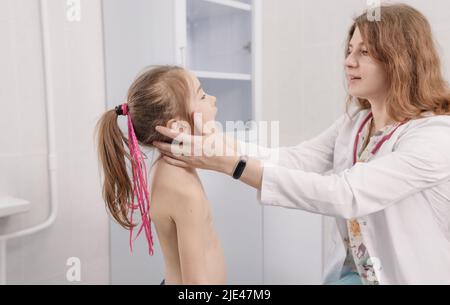 Eine Kinderärztin untersucht während einer Untersuchung die Mundhöhle eines kleinen Mädchens Stockfoto