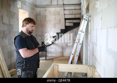 Man untersucht die Befestigung des Tisches im Bau Stockfoto