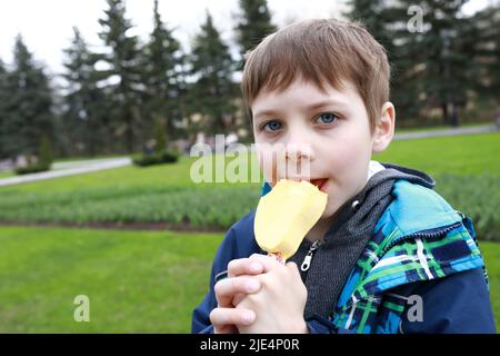 Kinder essen Mango-Eis im Park Stockfoto