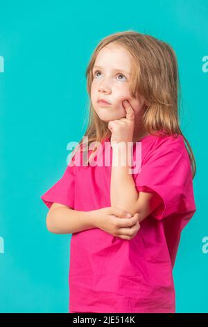 Ein 6-jähriges Mädchen ist als Arzt oder Krankenschwester gekleidet und scheint tief in Gedanken zu sein. Feminismus, MINT und Gesundheitskonzepte. Stockfoto