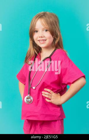 Ein 6-jähriges Mädchen ist als Arzt oder Krankenschwester mit einem Stethoskop um den Hals gekleidet. Feminismus, MINT und Gesundheitskonzepte. Stockfoto