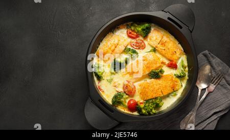 Cremige Knoblauchbutter, Toskanischer Lachs. Lachsfilet mit Sahnesauce, Kirschtomaten und Brokkoli Stockfoto
