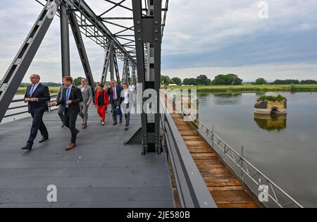 25. Juni 2022, Brandenburg, Neurüdnitz: Dietmar Woidke (SPD, l), Ministerpräsident von Brandenburg, und Karsten Birkholz (keine Parteizugehörigkeit), Bezirksdirektor Barnim-Oderbruch, gehen mit anderen Gästen zur Eröffnungsfeier über die Europabrücke, die eine Verbindung zwischen den beiden Ländern über die deutsch-polnische Grenze oder herstellt. Die ehemalige Eisenbahnbrücke zwischen der brandenburgischen Gemeinde Oderaue (Oderbruch) und dem polnischen Siekierki der westpommerschen Stadt Cedynia wurde am selben Tag für Fußgänger und Radfahrer geöffnet. Mietwagen können diese Verbindung nicht verwenden. Der Europ Stockfoto