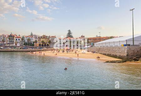 Cascais in der Nähe von Lissabon, Küstenstadt. Panoramablick auf den Strand, gefüllt mit ruhenden Menschen an einem sonnigen Sommertag. Portugal Stockfoto