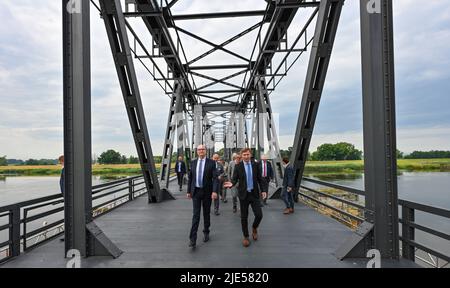 25. Juni 2022, Brandenburg, Neurüdnitz: Dietmar Woidke (l, SPD), Ministerpräsident von Brandenburg, und Karsten Birkholz (keine Parteizugehörigkeit), Bezirksdirektor Barnim-Oderbruch, gehen mit anderen Gästen zur Eröffnungsfeier über die Europabrücke, die eine Verbindung zwischen den beiden Ländern über die deutsch-polnische Grenze oder herstellt. Die ehemalige Eisenbahnbrücke zwischen der brandenburgischen Gemeinde Oderaue (Oderbruch) und dem polnischen Siekierki der westpommerschen Stadt Cedynia wurde am selben Tag für Fußgänger und Radfahrer geöffnet. Mietwagen können diese Verbindung nicht verwenden. Der Europ Stockfoto