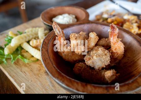 Draufsicht auf frittierte knusprige Garnelen und gebratene Kartoffeln auf der Seite. Stockfoto