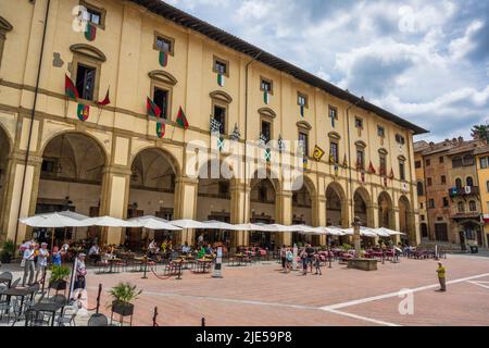 Cafés und Restaurants im Freien in der Loggia del Vasari auf der Piazza Grande (Nordseite) im historischen Stadtzentrum von Arezzo in der Toskana, Italien Stockfoto