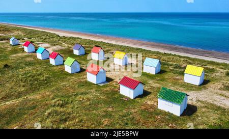 Luftbild von bunten Strandhütten, Sanddünen und dem Meer in Gouville, Frankreich. Stockfoto
