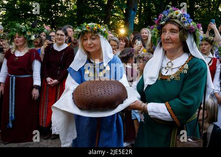 Frauen in litauischen Nationalkostümen führen während des Mittsommerfestivals in Vilnius Rituale mit frisch gebackenem Roggenbrot durch Stockfoto