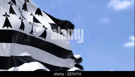 Rückansicht der bretonischen Flagge, die an einem klaren Tag im Wind schwenkt. Die Bretagne ist eine Halbinsel, ein historisches Land und ein kulturelles Gebiet im Westen Frankreichs Stockfoto