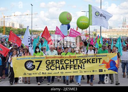 25. Juni 2022, Bayern, München: Teilnehmer halten ein Transparent mit der Aufschrift 'G7 Gerechtigkeit schaffen !' Während einer Demonstration der G7 Kritiker für einen besseren Klima- und Artenschutz sowie gegen Hunger und Armut. Fünfzehn globalisierungskritische Verbände haben zur Demonstration in München aufgerufen. Deutschland ist Gastgeber des Gipfeltreffens der wirtschaftlich starken Demokratien G7 (26.-28. Juni). Foto: Michael Kappeler/dpa Stockfoto
