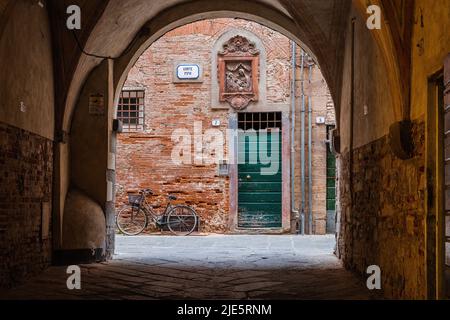 Lucca, Italien - 6/8/2022: Fahrrad in Ruhe in traditionellen toskanischen Hof in Lucca, Italien. Stockfoto