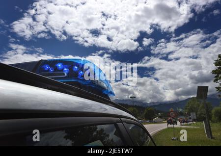 Garmisch Partenkirchen, Deutschland. 25.. Juni 2022. Ein Polizeiauto mit blauen Ampeln weist auf eine Verkehrskontrolle am Ortseingang hin. Am ersten Tag des Gipfels werden die globale Wirtschaftslage, der Klimaschutz sowie die Außen- und Sicherheitspolitik mit Sanktionen gegen Russland diskutiert. Quelle: Karl-Josef Hildenbrand/dpa/Alamy Live News Stockfoto