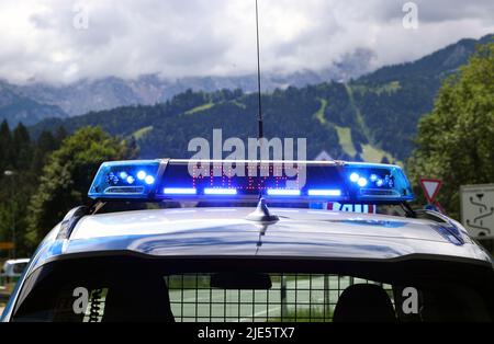 Garmisch Partenkirchen, Deutschland. 25.. Juni 2022. Mit blauen Lichtern und dem Display „Police“ steht ein Polizeifahrzeug an einer Verkehrskontrolle. Am ersten Tag des Gipfels werden die globale Wirtschaftslage, der Klimaschutz sowie die Außen- und Sicherheitspolitik mit Sanktionen gegen Russland diskutiert. Quelle: Karl-Josef Hildenbrand/dpa/Alamy Live News Stockfoto