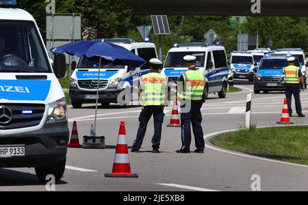 Garmisch Partenkirchen, Deutschland. 25.. Juni 2022. Polizeiautos passieren eine Verkehrskontrolle am Ortseingang. Am ersten Tag des Gipfels werden die globale Wirtschaftslage, der Klimaschutz sowie die Außen- und Sicherheitspolitik mit den Sanktionen gegen Russland diskutiert. Quelle: Karl-Josef Hildenbrand/dpa/Alamy Live News Stockfoto