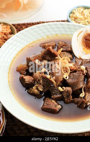 Ausgewählte Focus Rawon, indonesische traditionelle Beff Black Soup aus Ost-Java. Serviert auf einer Schüssel mit Shrimp Cracker (Kerupuk Udang) und Chili Paste und Stockfoto