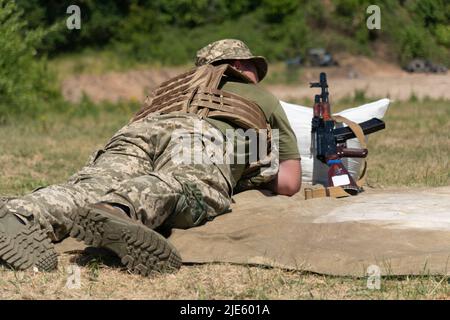 Soldat wartet auf einen Schuss von einem Maschinengewehr ak 47. Stockfoto