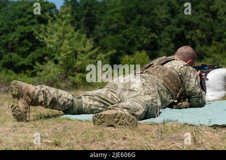 Das ukrainische Militär feuert aus einem Maschinengewehr. Stockfoto