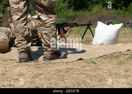Das ukrainische Militär feuert aus einem Maschinengewehr. Stockfoto