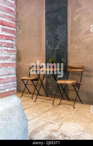 Ein kleiner Couchtisch und zwei Stühle in den Straßen des Stadtteils El Born in Barcelona im Sommer Stockfoto
