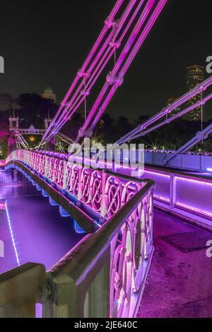 Alte hell erleuchtete Brücke auf dem Singapur Fluss in der Nacht Stockfoto