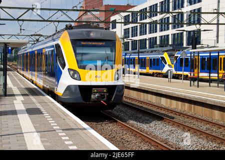 SNG-Nahverkehrszug von NS auf der anderen Seite von Den Haag Mariahoeve mit gelbem Kopfbemalung Stockfoto