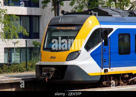 SNG-Nahverkehrszug von NS auf der anderen Seite von Den Haag Mariahoeve mit gelbem Kopfbemalung Stockfoto