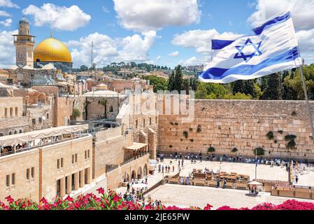 Jerusalem, Israel; 25. Juni 2022 - eine israelische Flagge weht in den Wind, als jüdische orthodoxe Gläubige die Tora lesen und vor der Westmauer beten Stockfoto