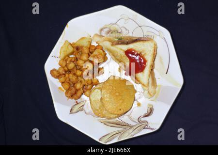 Köstliches Frühstück auf dem Teller Sandwich Cholay Bhature auf dem Teller auf schwarzem Hintergrund Punjab Lahore Pakistan Stockfoto